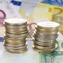 zu Türmen gestapelte Euromünzen, darunter Euroscheine